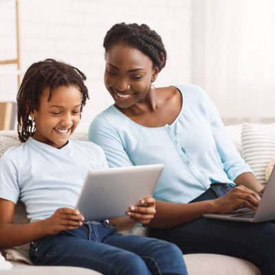 afro-mom-and-daughter-doing-school-homework-on-sof-QHHEQDH.jpg